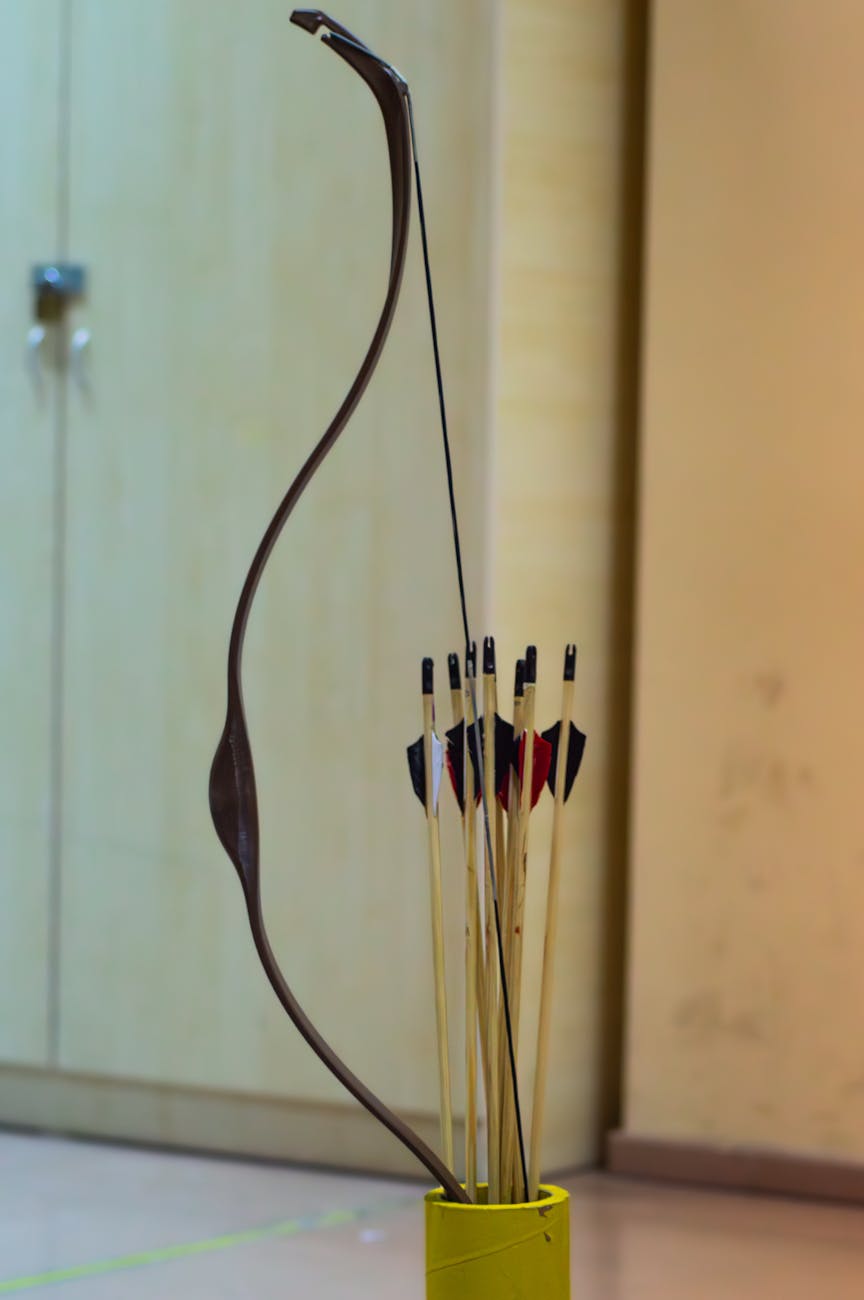 traditional archery bow with arrows indoor setup