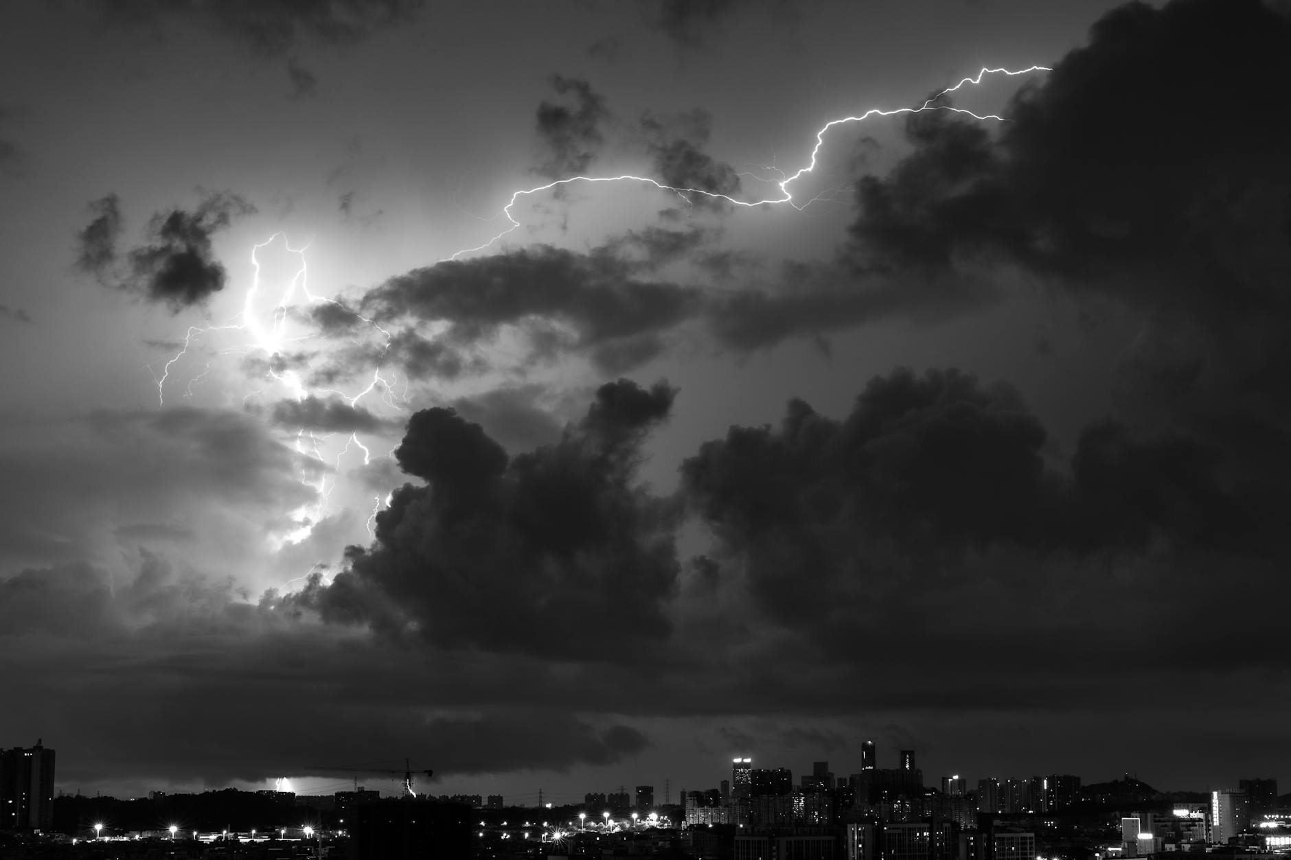 grayscale photo of city buildings under cloudy sky